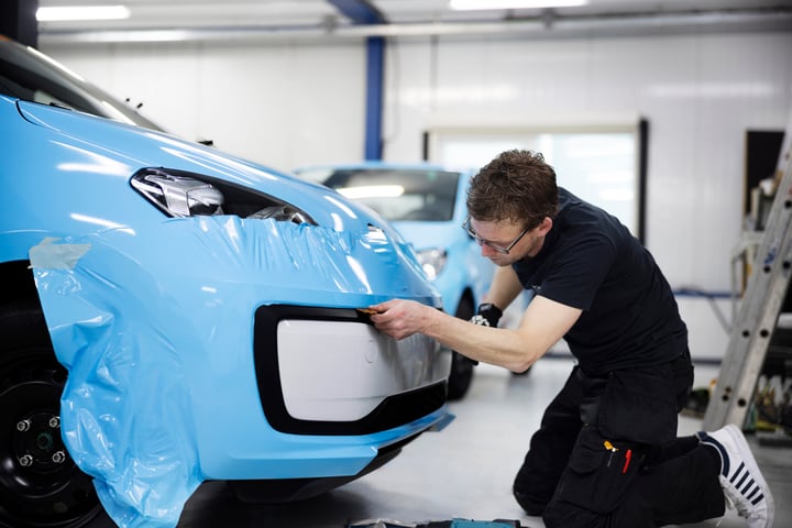 man-wrapping-car-with-blue-cover-full-shot